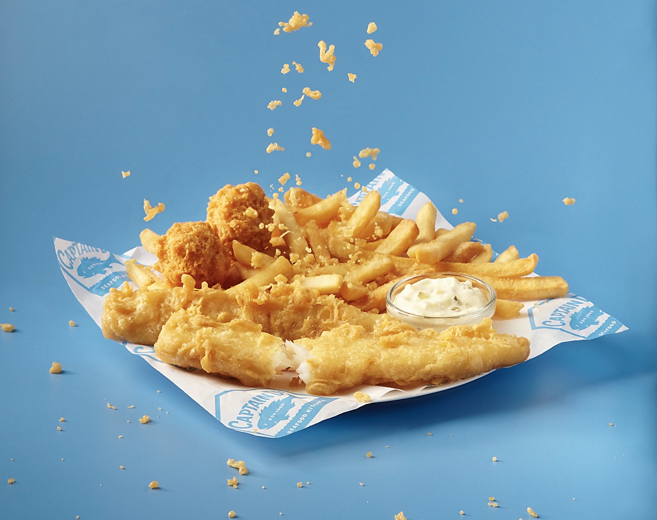 Battered fish, French fries, hush puppies and sauce.